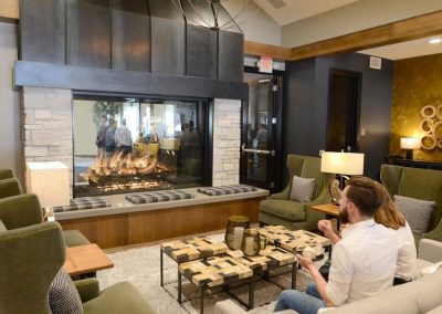 Croft Fireplace two-sided gas fireplace in a contemporary lounge with wood accents and cozy seating