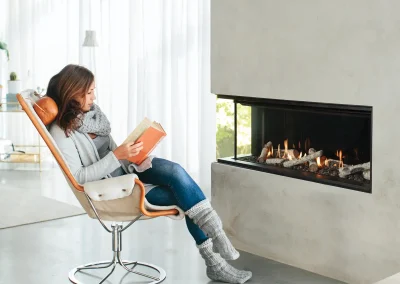 Croft Fireplace corner linear gas fireplace beside a reading nook with lounge chair and footrest