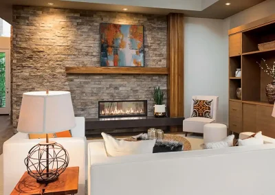Modern living room with stone fireplace, wood accents, and cozy seating
